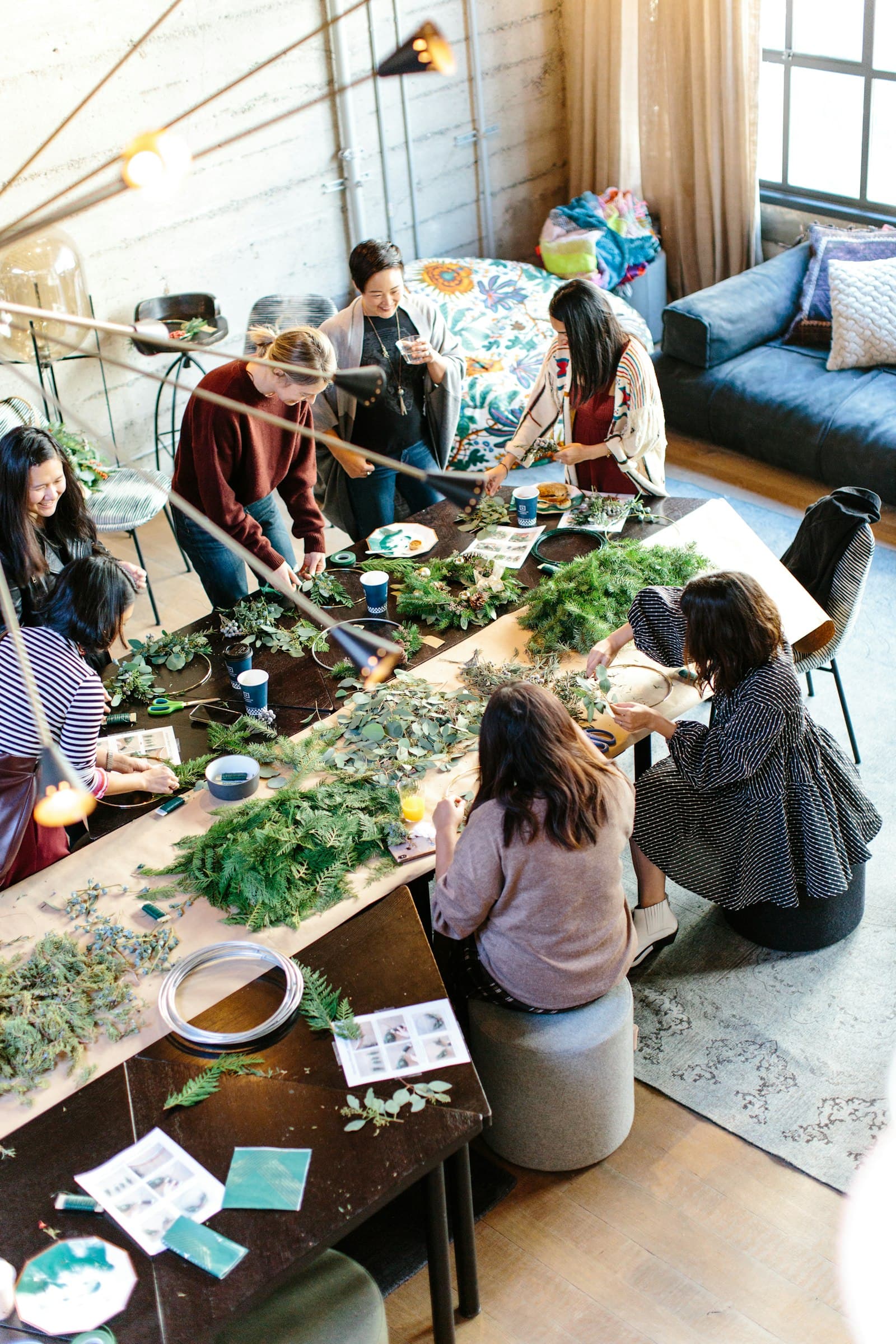 A group gathered around a table making wreaths together in a workshop